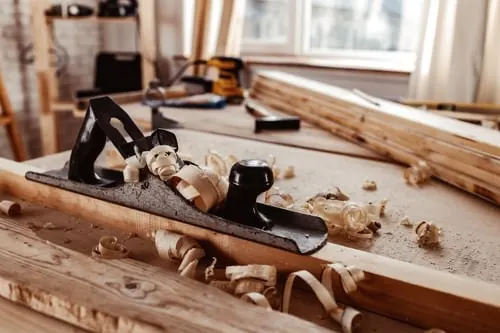 Carpenter's hand plane and tools on a workbench, representing Oro Carpentry's craftsmanship