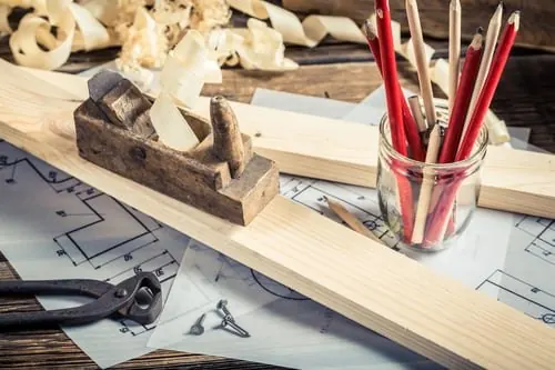 Carpenter's hand plane and woodworking tools on a workbench with fresh shavings